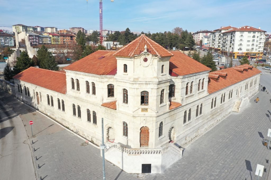 Aerial view of a historic stone building with red tile roofs in Sivas, Turkey, on a sunny day. — Advantages for Employers