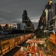 Cityscape at twilight showing busy traffic, skyscrapers, and an elevated train line in an urban setting. — "MetaTrader 4 Andr