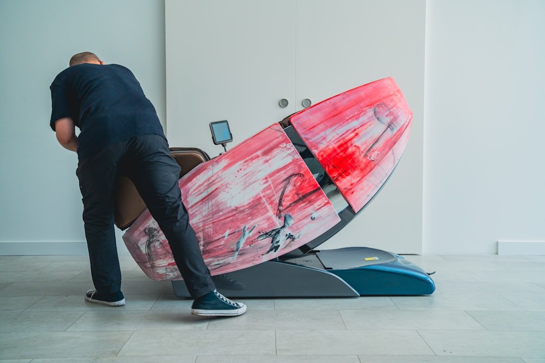 Person adjusting a massage chair in a clean, modern space.