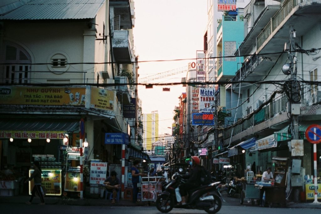 Colorful busy street scene in Cần Thơ, Vietnam with vibrant signs and people. — Providing Safe and Exciting Spaces for Childr
