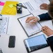 Team reviewing financial charts and digital data on tablets in an office setting. — Request AL Renters Insurance Quotes for F