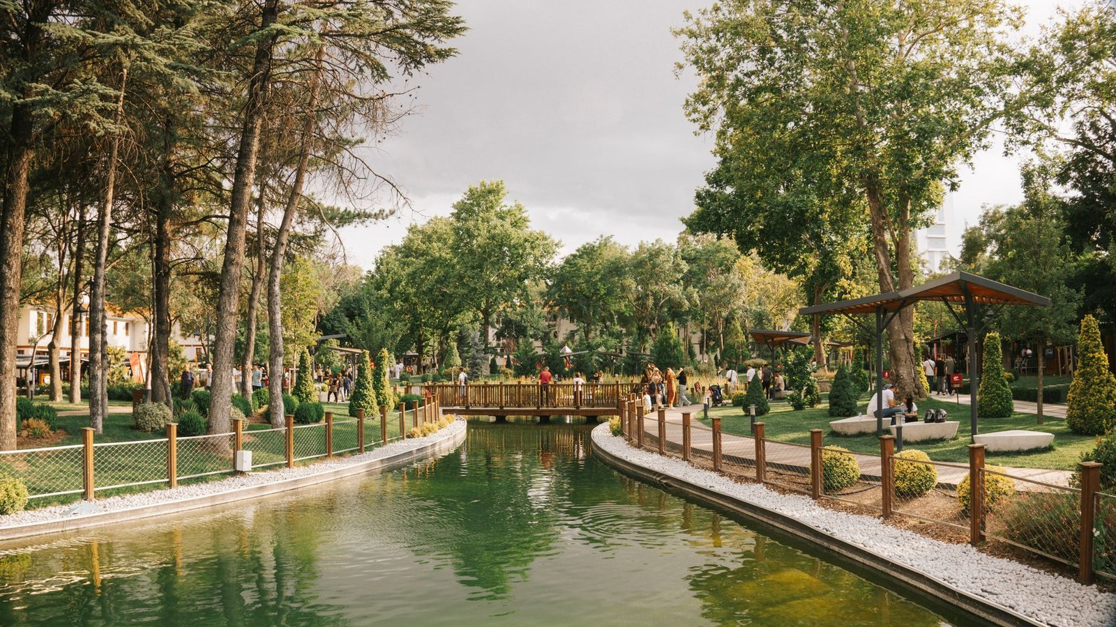 Peaceful park scene featuring a serene pond, a wooden bridge, and lush greenery. — Start Your Global Veterinary Career: Inter